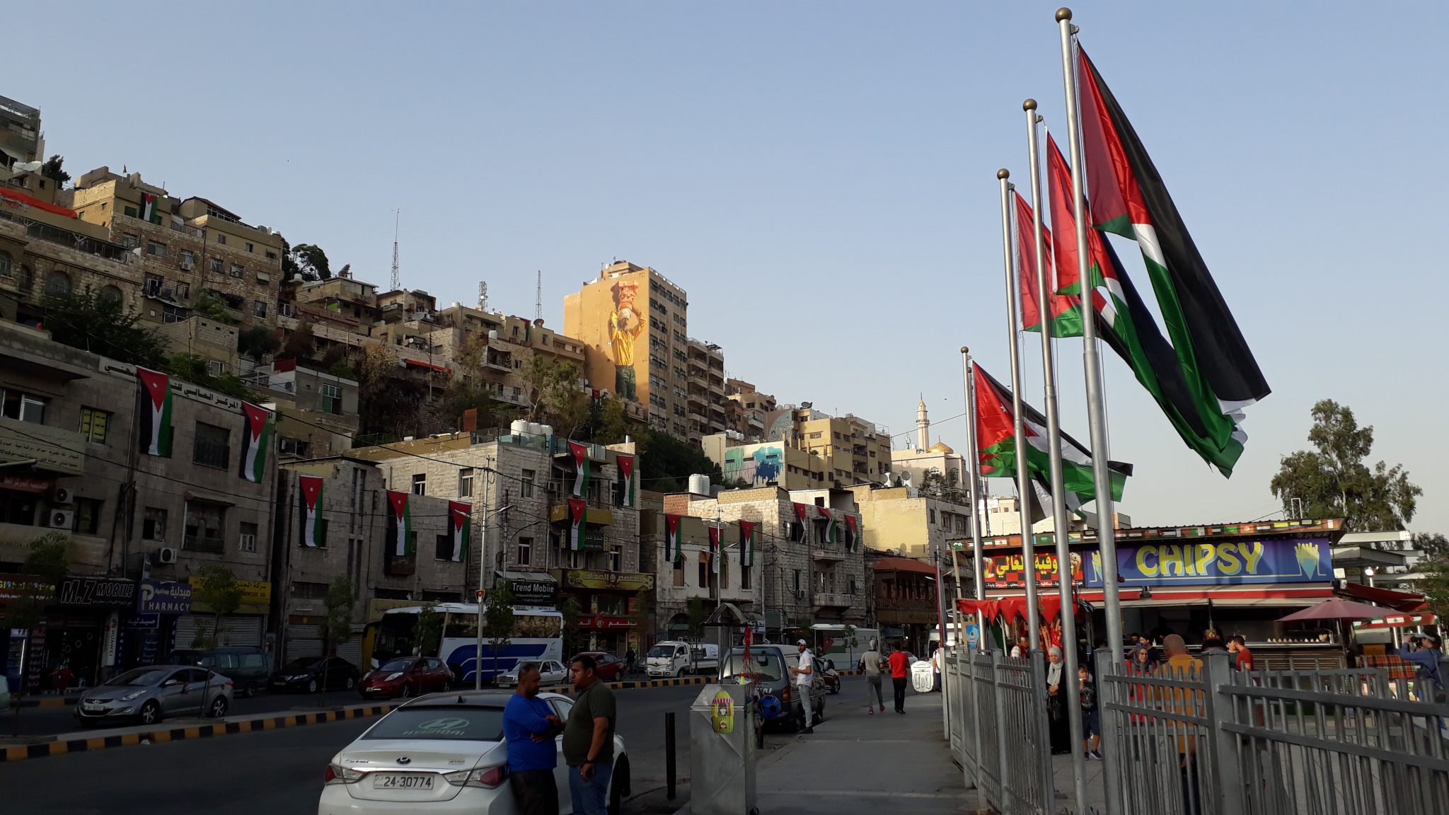 Die Innenstadt von Amman; (Wohnhäuser auf der linken, Fahnen auf der rechten Seite)